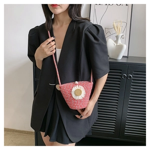 Détail du mini sac bandoulière tressé rouge et blanc avec marguerite et bouton perle