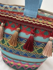 Dettaglio della trama intrecciata bohémien colorata e nappe sulla borsa a mano