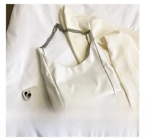 Détail du sac hobo blanc crème avec cuir lisse et bandoulière en chaîne argentée