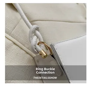 Détail du sac à bandoulière en cuir blanc avec anneau en D doré et sangle nouée