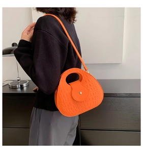 Détail du sac à main orange vif en similicuir avec motif crocodile et boucle en métal