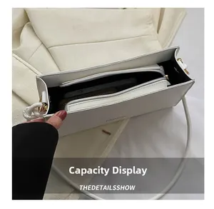 Vue intérieure du sac blanc minimaliste montrant la poche zippée et l'espace pour téléphone