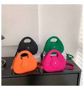 Gros plan sur la texture crocodile de sacs en feutre colorés avec poignées rondes