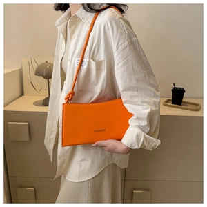 Détail d'un sac à bandoulière rectangulaire orange vif avec lettrage FASHION