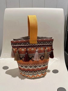 Dettaglio della borsa a secchiello bohémien con frange colorate e motivi geometrici