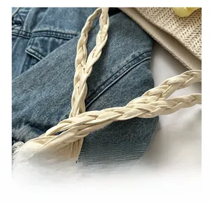 Close-up of the woven cream faux leather handle detailing on a casual summer tote bag