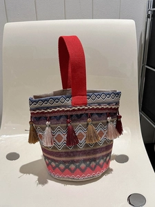 Dettaglio della borsa etnica ricamata con motivi geometrici colorati e nappe vivaci