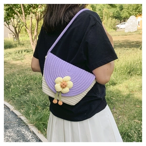 Vista trasera del bolso bandolera tejido morado y blanco con flor amarilla y borla verde