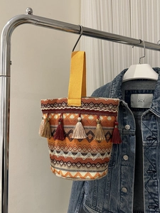 Dettaglio della borsa tessuta bohémien con motivi geometrici colorati e nappe decorative