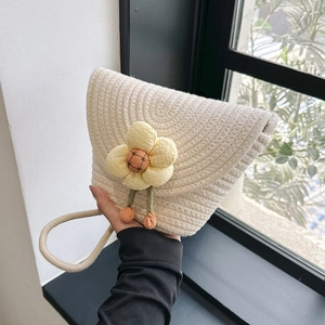 Detailweergave van handgemaakte crème gehaakte mini schelptas met gele bloem en oranje pompons