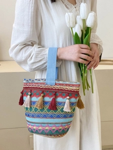 Dettaglio della borsa tessuta bohémien con motivi geometrici colorati e nappe decorative