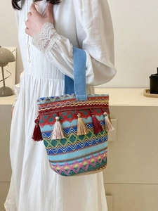 Borsa a secchiello etnica con motivi ricamati colorati ed eleganti nappe laterali