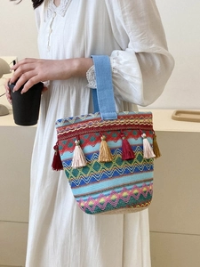 Dettaglio della borsa a secchiello etnica intrecciata con nappe e motivi geometrici