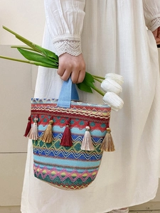 Dettaglio di borsa boho tessuta colorata con nappe di seta e ricami fini