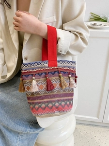 Dettaglio borsa etnica ricamata con nappe colorate e trama in stile bohémien