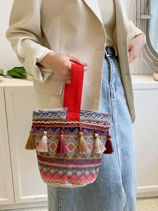 Dettaglio del motivo geometrico colorato e nappe a frangia su borsa boho a secchiello
