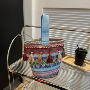 Dettagli del ricamo etnico geometrico e nappe colorate sulla borsa a mano in tessuto