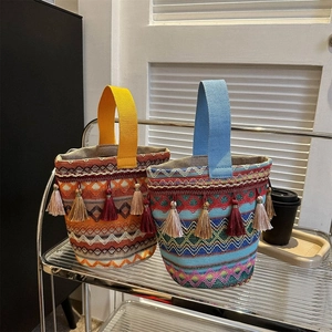 Vista dettagliata di borse a secchiello boho in tessuto con motivi colorati e frange