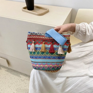 Dettaglio della trama geometrica colorata e nappa decorativa della borsa boho