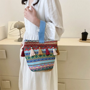 Dettaglio della borsa tote boho tessuta con motivi etnici colorati e nappe con frange