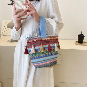 Dettaglio di borsa boho tessuta con motivi a onde colorate e nappe in seta morbida
