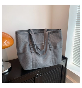 Detail of grey mesh beach tote bag featuring functional vertical loops and wide handle