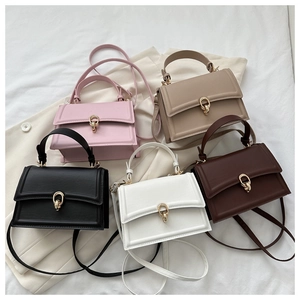 Flat lay of small crossbody square bags in five colors with gold double ring lock