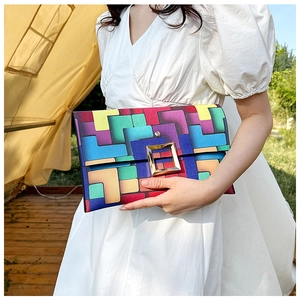 Dettaglio della borsa a busta con motivi geometrici colorati e fibbia quadrata dorata