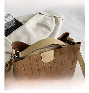 Detail shot of brown V-quilted tote bag featuring soft handles and gold hardware