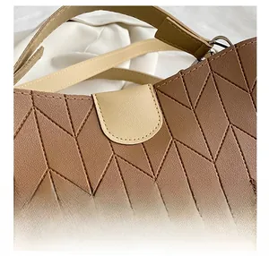 Detail showing geometric diamond stitching on brown leather texture with silver metal ring