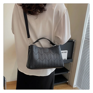 Detail of black quilted tote bag with silver hardware on a lifestyle model
