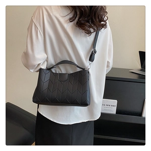 Detailed back view of a black quilted leather handbag with silver hardware on a model