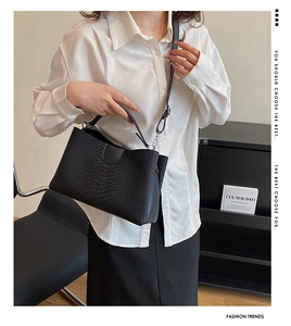 Detail of black crocodile pattern leather tote bag with silver hardware on model