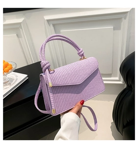 Detail showing lavender woven texture and gold metal hardware on the square shoulder bag