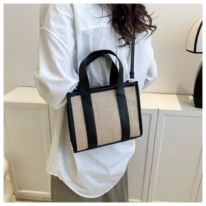 Dettaglio della borsa in paglia intrecciata con finiture in pelle nera e tracolla