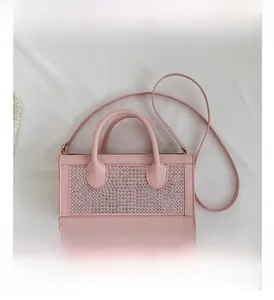 Detail view of pink rectangular handbag with shimmering silver rhinestones and round handles