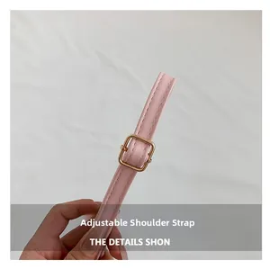 Detailed view of pink leather adjustable shoulder strap with golden metal buckle