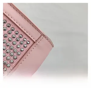 Macro detail of pink leather handbag with silver rivets and precise stitching