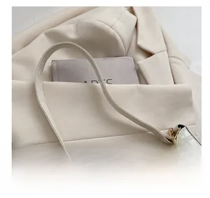 Primer plano de bolso blanco con textura de cocodrilo y detalle de cadena dorada