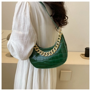 Vista detallada de bolso de hombro verde oscuro con estampado de cocodrilo y strass.