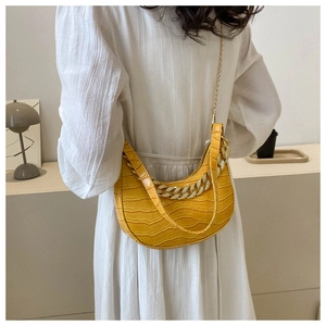 Vista detallada del bolso de hombro hobo amarillo con estampado de cocodrilo y cadena elegante.