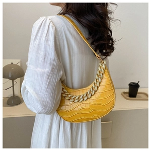 Vista detallada del bolso de hombro amarillo efecto cocodrilo con cadena de pedrería.