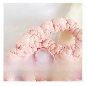 Close-up of the soft pleated cloud-style handle on a pink minimalist shoulder bag