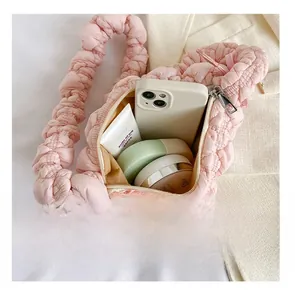 Internal capacity of pink quilted cloud bag showing phone and cosmetics inside