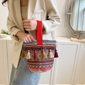 Borsa a secchiello etnica intrecciata con strisce colorate, nappe e manico rosso
