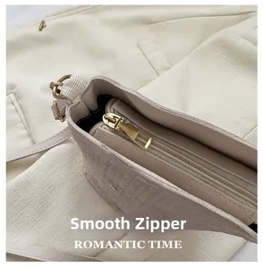 Détail du zip doré lisse sur un sac en paille beige avec une texture en tissu