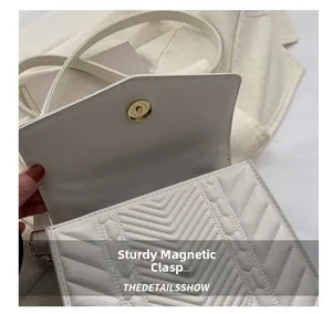Dettaglio della borsa trapuntata bianca con chiusura magnetica dorata e motivo a V