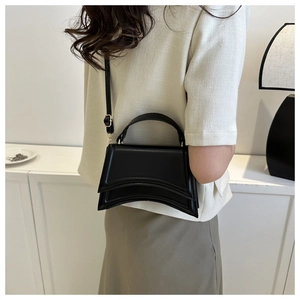 Vue arrière du mannequin portant un sac à main sablier noir avec base incurvée et bandoulière
