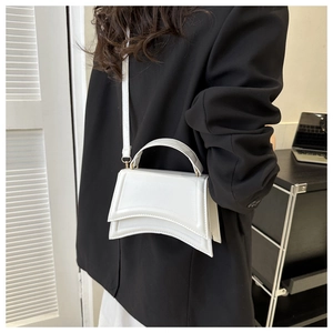 Détail du sac à main sablier blanc en cuir avec base incurvée et poignée supérieure élégante