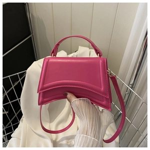 Gros plan sur le sac à main sablier fuchsia en cuir lisse avec des détails métalliques dorés